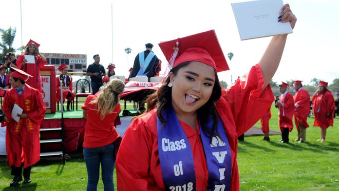 Kayla Gonzales of Hueneme High School celebrates after getting her diploma in Oxnard.