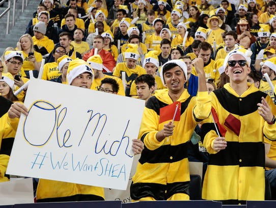 A Michigan fan holds a sign of #WeWantSHEA, referring