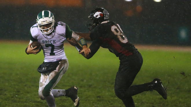 Brick running back Ja'Sir Taylor (white uniform No. 7), shown being pursued  by Jackson Memorial defensive end Tyler Towns, and Jackson Memorial will meet Friday night in an NJSIAA Central Group IV quarterfinal
