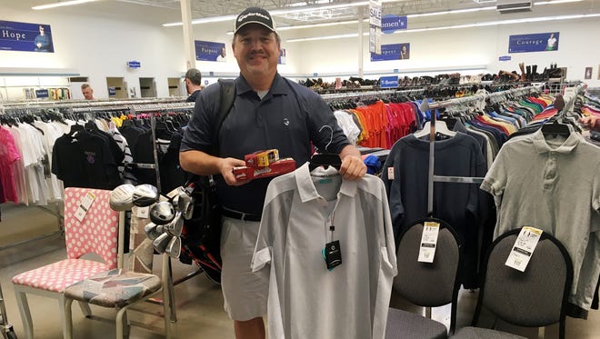 Ron Smith, who coined the phrase "Good Will Golfing" to describe his frugal foray into golf, shows off some of his recent finds from Goodwill stores.