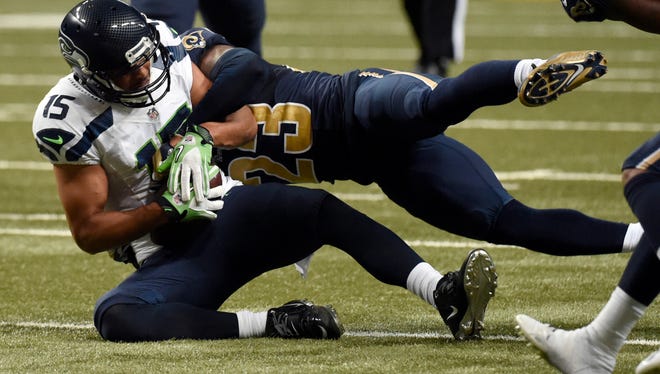Seattle Seahawks wide receiver Jermaine Kearse, left, holds on to the ball after catching a pass for a 9-yard gain as St. Louis Rams free safety Rodney McLeod defends during the third quarter of an NFL football game Sunday, Sept. 13, 2015, in St. Louis.
