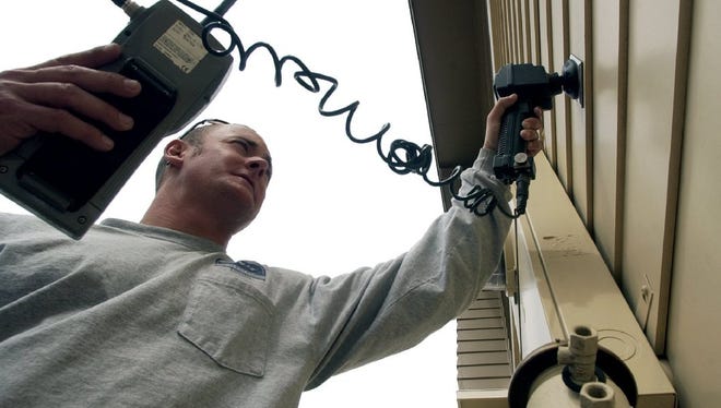 Dan Jackson of Fort Collins Utilities touches a VersaProbe to a touch pad to read the water register at a home off Bennett Street in this 2006 file photo.
