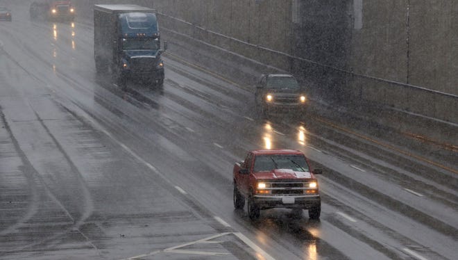 Automobiles travel south along Interstate 75 Tuesday morning as snow falls at the Lockland split.
