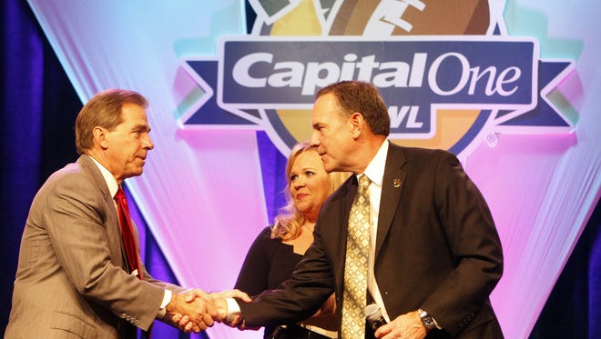Alabama coach Nick Saban, left, and Michigan State coach Mark Dantonio shake hands before the Capital One Bowl that was played on Jan. 1, 2011. Dantonio coached defesive back under Saban at MSU. ESPN reporter Holly Rowe looks on.