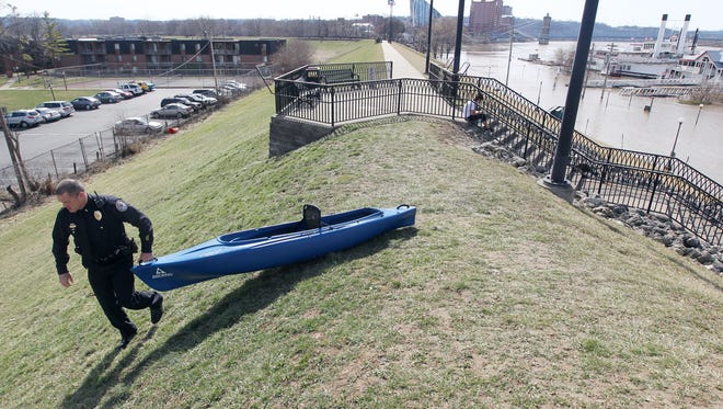 Newport Police Lt. Paul Kunkel pulls a kayak down the Newport floodwall after a man kayaking fell in the river.