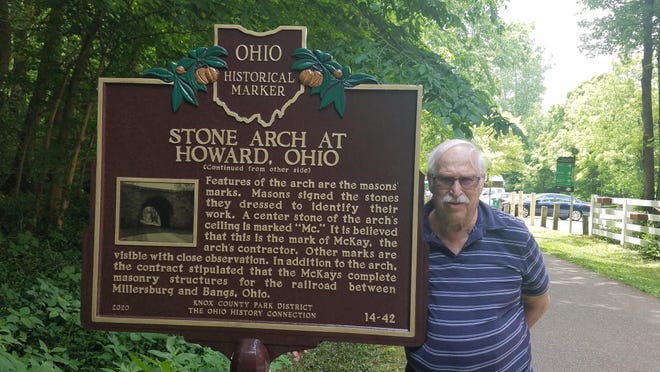 Longtime Monroe resident David McKay stands next to the historic marker he helped get installed along the Kokosing Gap Bike Trail in Central Ohio. McKay's great-grandfather and grandfather built a stone arch that runs over the trail, which used to a rail line.