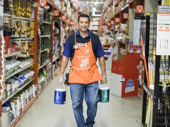 A Home Depot employee carrying cans of paint.