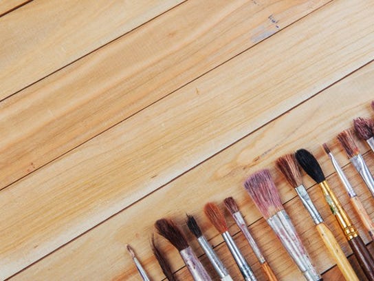 Paintbrushes and art tools on a wooden table background