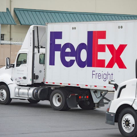 Two FedEx trucks at a distribution center