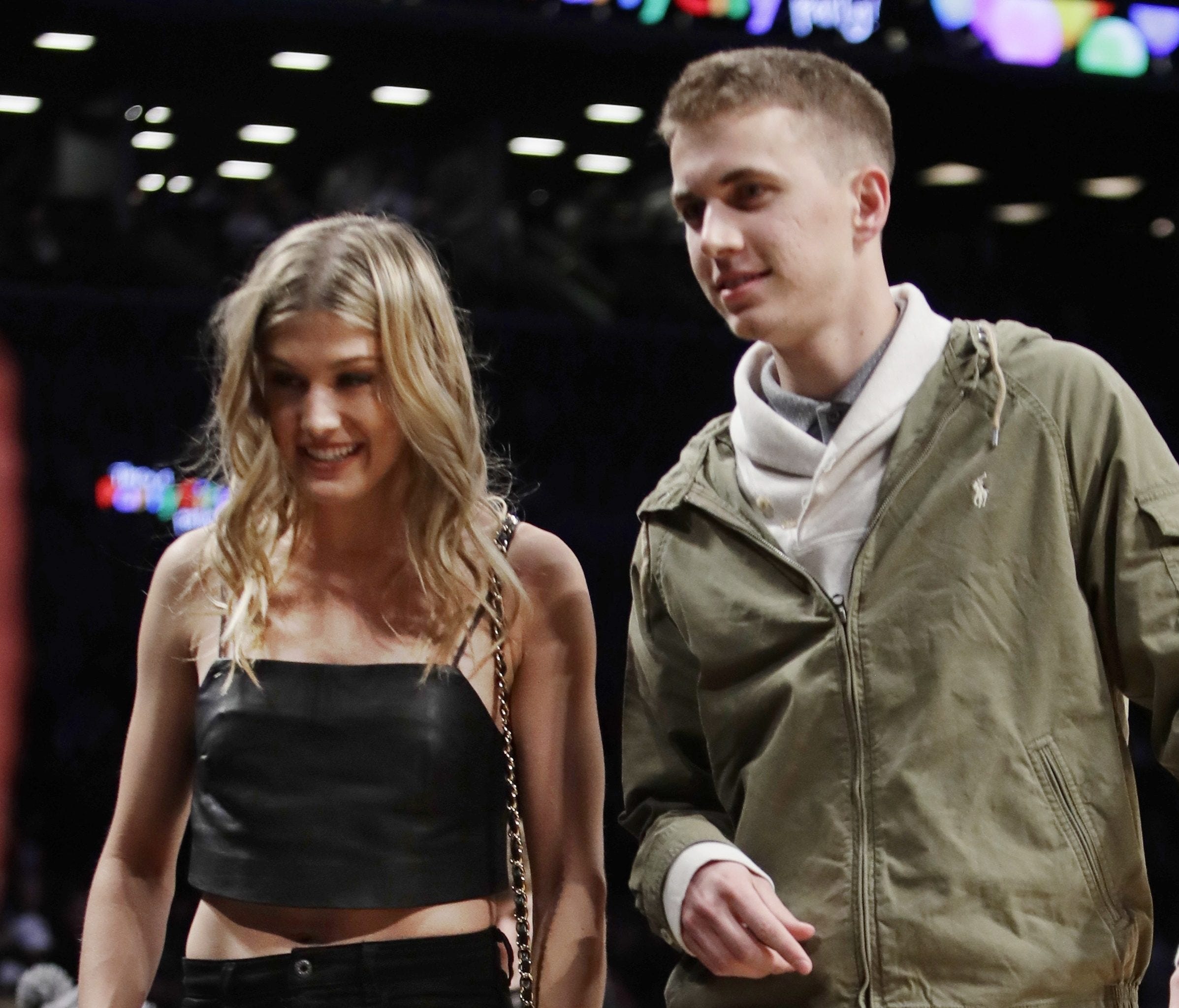 Genie Bouchard, walks the court with her blind date, John Goehrke, right, during the first half of an NBA basketball game between the Brooklyn Nets and the Milwaukee Bucks Wednesday, Feb. 15, 2017, in New York. After losing a Super Bowl bet on Twitte