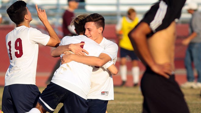 La Quinta High School's Carlos Ortega (19,white, left), Isaac Sanchez (4, white, center) and Daniel Alexander (15, white, right) celebrate on the field and hug each other as a Sunny Hills player walks off the field with his jersey pulled over his head following the Blackhawks' 1-0 CIF semifinal playoff victory at home on Tuesday afternoon, March 3, 2015. La Quinta advances to the CIF title game, which will be held later this week.