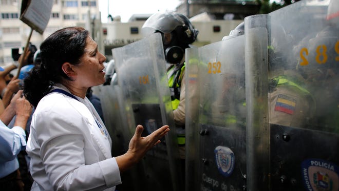 A woman confronts a line of police officers in riot gear during an anti-government protest in Caracas, Venezuela, Monday, May 22, 2017. At least 46 people have died during the two-month anti-government protest movement. (AP Photo/Ariana Cubillos)