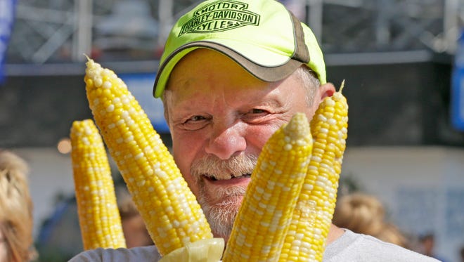 Wes Hotchkiss of Beaver Dam holds ears of corn during the opening day of the 2016 Wisconsin State fair at State Fair Park in West Allis.