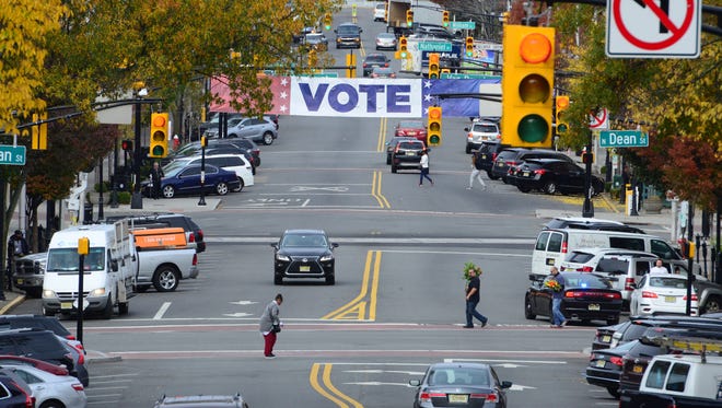 A large sign telling citizens to vote hangs over Palisades Ave in downtown Englewood Tuesday morning. 