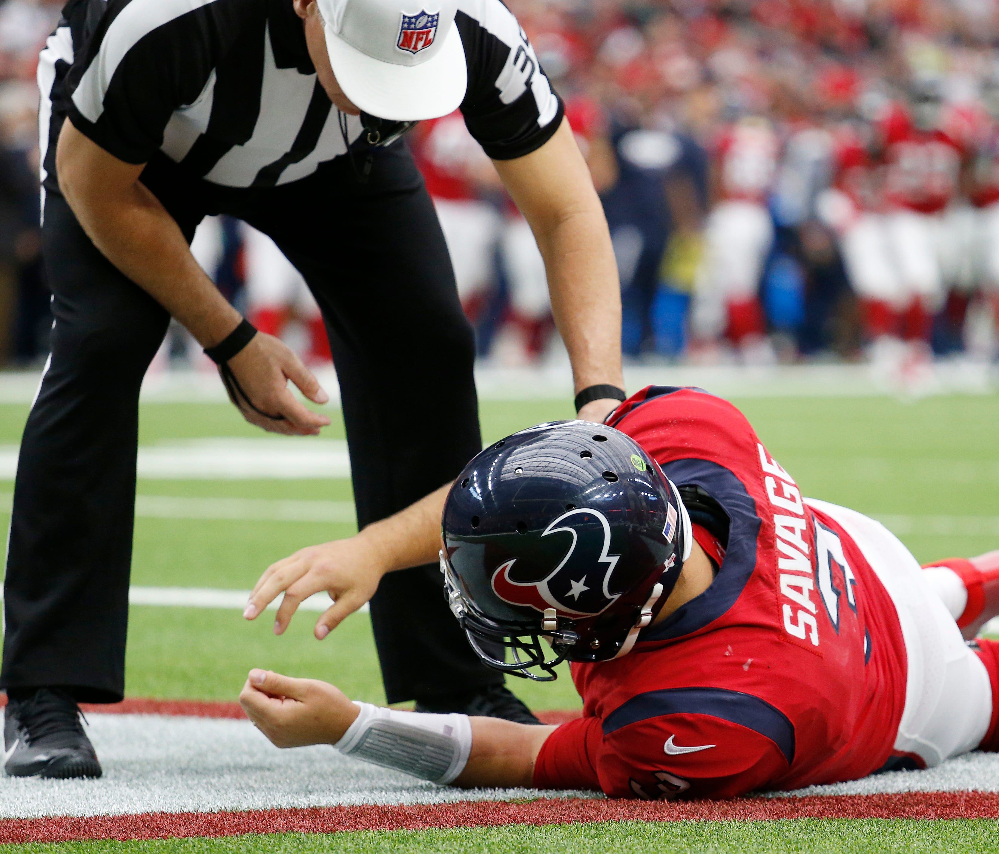 Referee John Hussey checks on Houston Texans quarterback Tom Savage after the hit that would ultimately knock him out of Sunday's game with the 49ers.