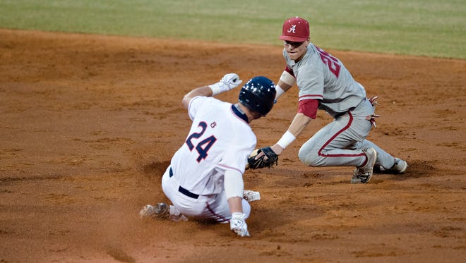 Auburn player Conor Davis slides safely in to second as Alabama infielder Jett Manning (26) attempts to tag him during the Capitol City Classic between Alabama and Auburn on Tuesday, March 27, 2018, in Montgomery, Ala.