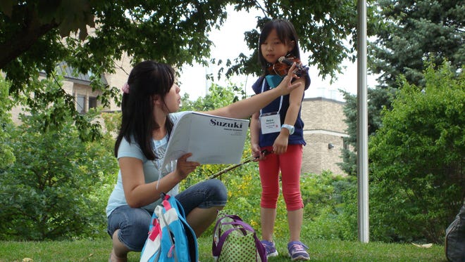 Violin student Anya Sulaiman, Marshfield, works closely with her mom, Lily, at the 2015 American Suzuki Institute at UW-Stevens Point. Sponsored by the Aber Suzuki Center on campus, the annual event brings generations together for intensive study of instrumental and vocal music through the teachings of Shinichi Suzuki.