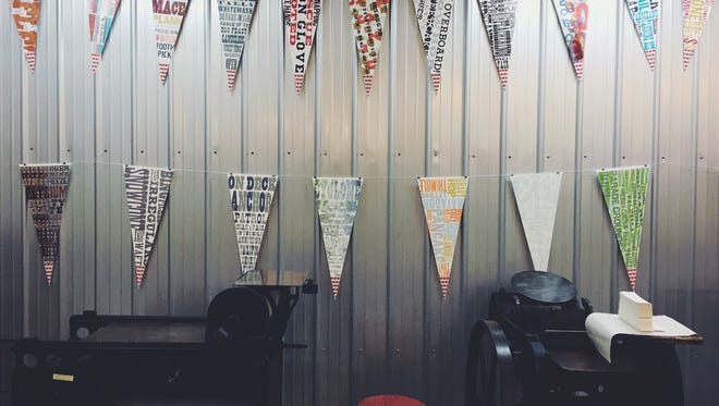 Letterpress pennants hang in an exhibition by former IU letterpress instructor and designer Tom Walker in the Book Arts Collaborative makerspace located in downtown Muncie. The Interrobang celebration of the book will feature speakers, demonstrations, and the release of Book Arts Collaborative’s culminating project, an artist’s book titled “Spaces between Places.”