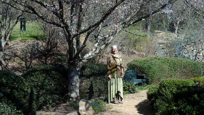 Shelli Stanback stands in the meditation garden of the OM Sanctuary campus in Asheville on Wednesday, March 23, 2016.  The non-profit has placed much of their 54 acre property on a conservation easement protecting an urban forest near the French Broad River. 
