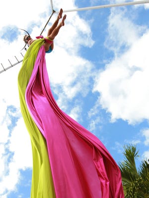 Andrea Weaver of Circus Arts United practices on the silks for an aerial performance at Friday’s Mystery Walk in downtown Fort Myers.