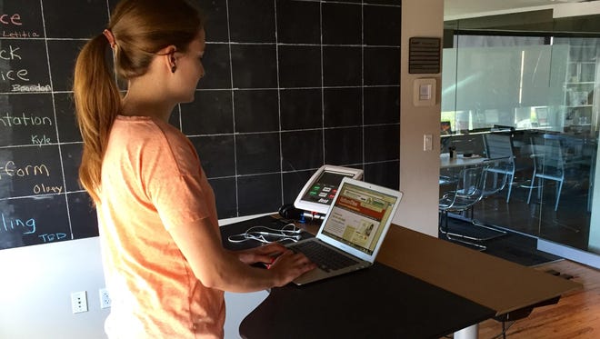Lauren Walsh, a content producer in marketing at WebPT, works while walking at a treadmill desk. WebPT has made health and wellness one of its eight “core values.”