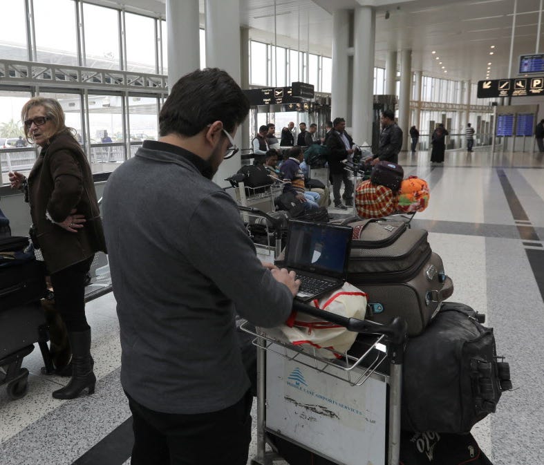 A Syrian passenger travelling to the United States through Amman types on his laptop before entering Beirut international airport's departure lounge on March 22, 2017.
