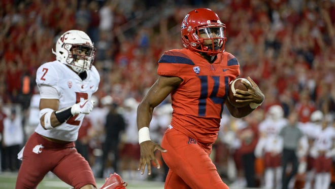 Arizona Wildcats quarterback Khalil Tate (14) runs the ball for a touchdown under pressure from Washington State Cougars defensive back Robert Taylor (2) during the second half at Arizona Stadium.
