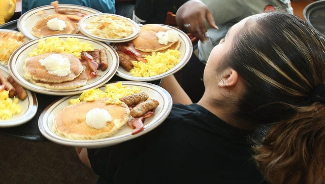 Denny's waitresses deliver free Grand Slam breakfasts to customers in Emeryville, California.