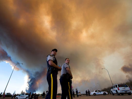 Police officers direct traffic under a cloud of smoke