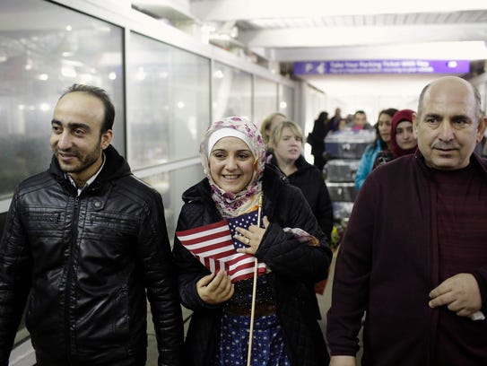 Syrianrefugee Baraa Haj Khalaf holds an American flag