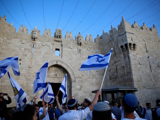 Israelis wave national flags outside the Old City's