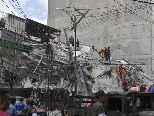 Rescuers work on the rubble from a building knocked