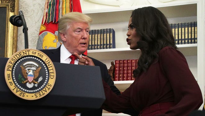 President Donald Trump listens to then-White House aide Omarosa Manigault during an event in the Oval Office of the White House Oct. 24, 2017 in Washington.