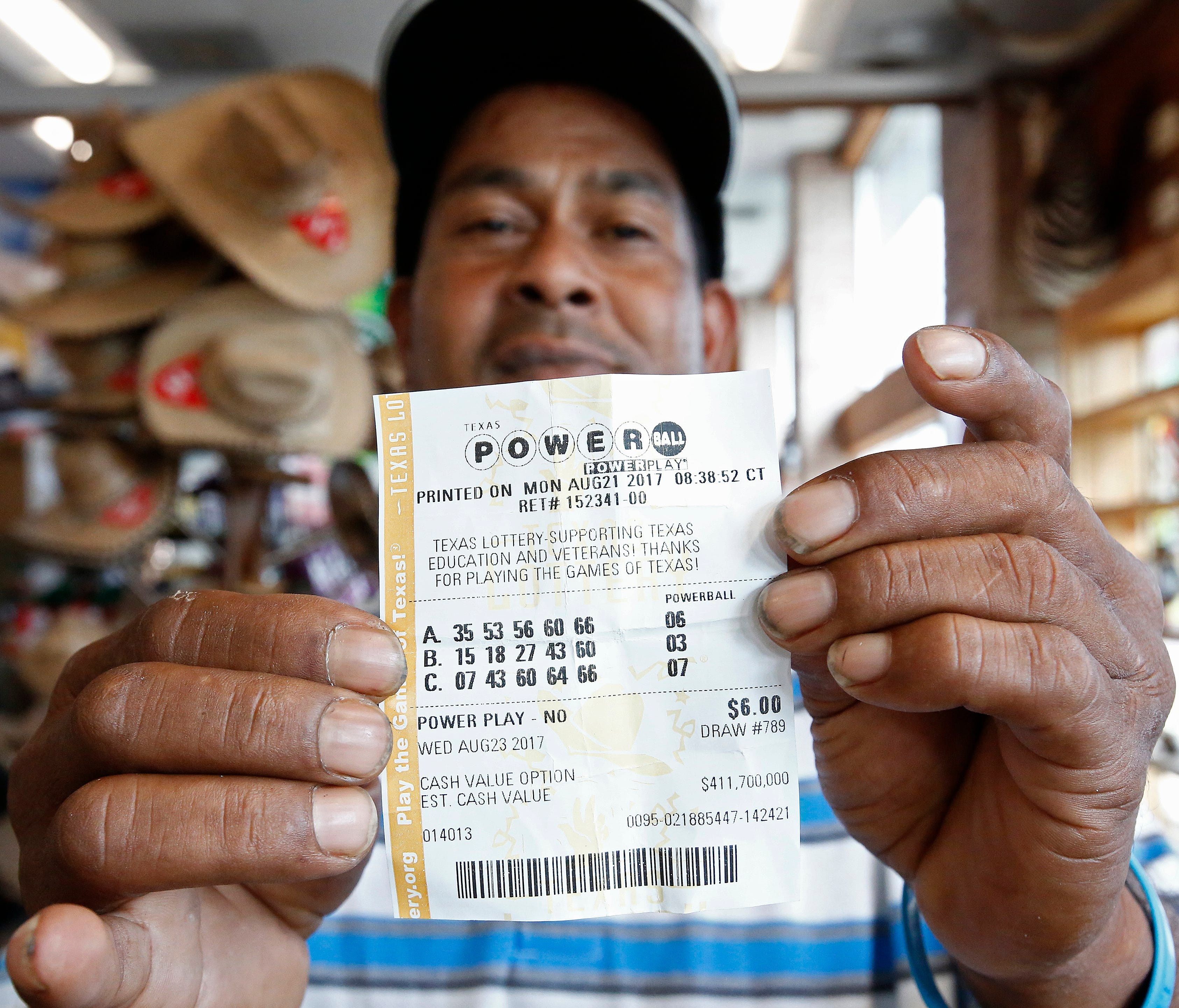 This man in Dallas TX holds up a Powerball lottery ticket he purchased at a gas station Aug. 23, 2017. The Powerball is at $700.