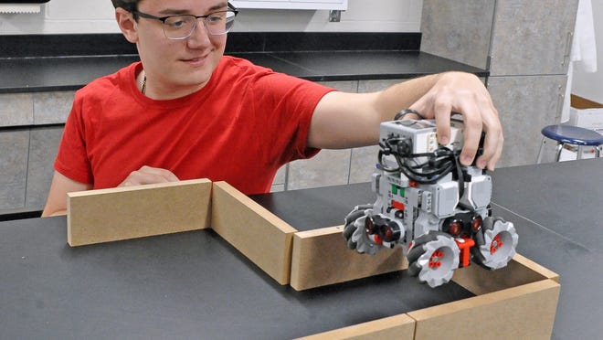 Andrew Magyar, a senior at Chippewa JR/SR High School, positions Atto, a robot programmed to solve traveling through a maze, in the STEM lab on Thursday.