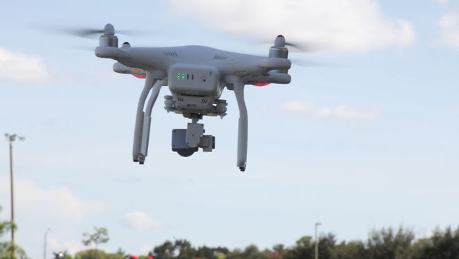 A DJI Phantom 3 Professional drone operated by Mark Harden flies over the practice field at Southwest Florida Christian Academy.