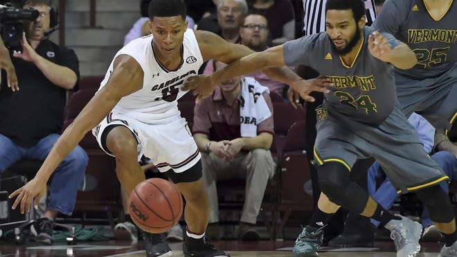 South Carolina’s PJ Dozier, left, battles Vermont's Dre Wills for a loose ball during the first half of an NCAA college basketball game against Vermont on Thursday in Columbia, S.C.