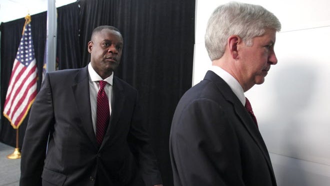 Michigan Gov. Rick Snyder (R) and Detroit's emergency manager Kevyn Orr (L) exit a press conference after addressing Detroit's bankruptcy filing July 19, 2013 in Detroit, Michigan.