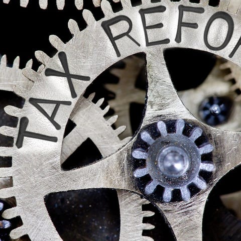 Clockwork gears in metal, with the words "Tax...