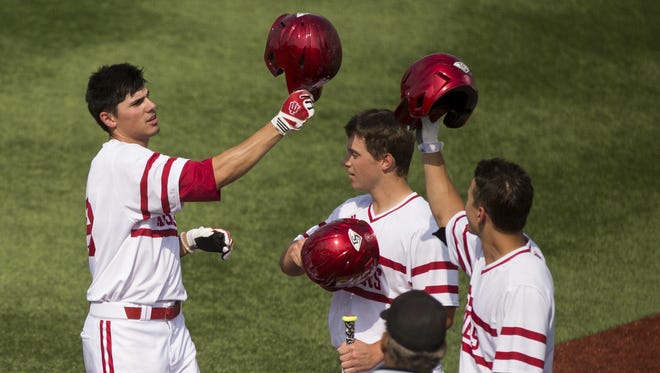 Indiana's Craig Dedelow, left, celebrates with teammates at home plate after hitting a two-run home run in the 7th inning during an NCAA college baseball game, May 15, 2015, at Bart Kaufman Field in Bloomington.