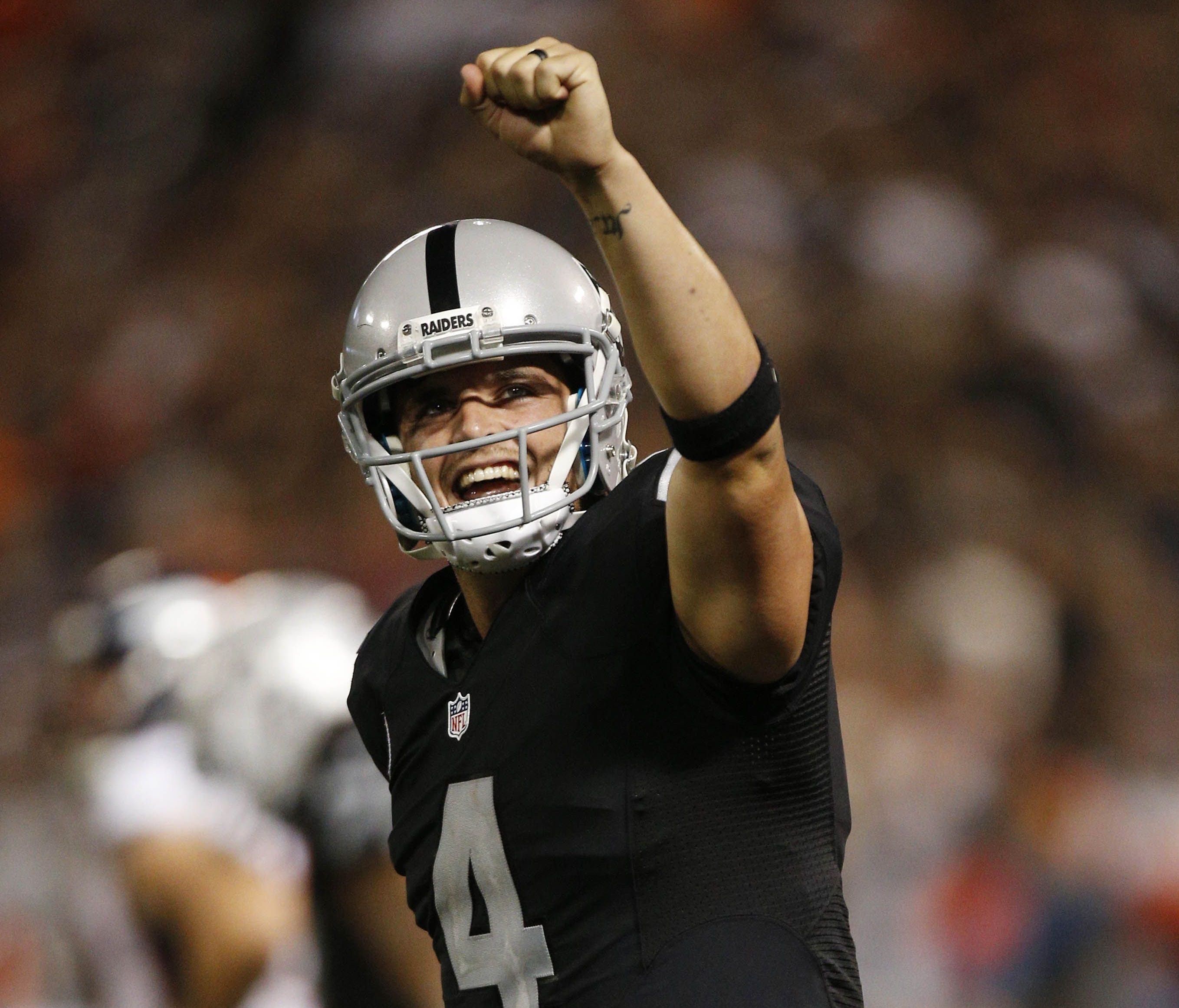 Oakland Raiders quarterback Derek Carr (4) reacts after the Raiders rushed for a touchdown against the Denver Broncos in the fourth quarter at Oakland Coliseum.