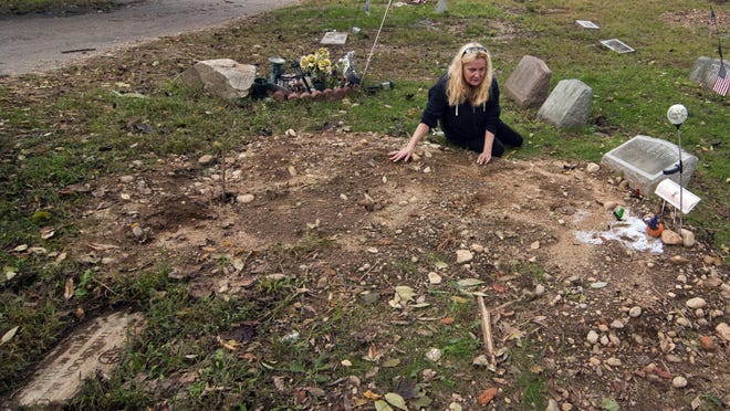 FILE - In this Oct. 3, 2018 file photo, a distraught Jean Stott, of Shelton, Conn., tries to find the exact spot where a family member is located after the tombstone, had been moved at Park Cemetery in Bridgeport, Conn. A mass desecration of graves at the cemetery has devastated dozens of families while police determine whether to file criminal charges. Authorities say gravestones and human remains at Park Cemetery in Bridgeport were moved to make way for the newly dead. (Christian Abraham/Hearst Connecticut Media via AP, File)