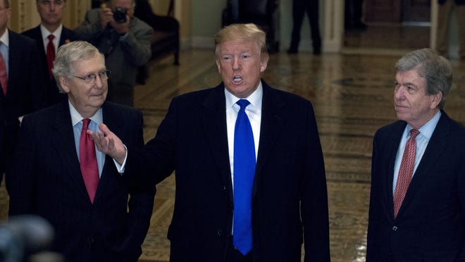 President Donald Trump accompanied by Senate Majority Leader Mitch McConnell of Ky., left, and Sen. Roy Blunt, R-Mo., right, talks to reporters as he arrives for a Senate Republican policy lunch on Capitol Hill in Washington, Tuesday, March 26, 2019.