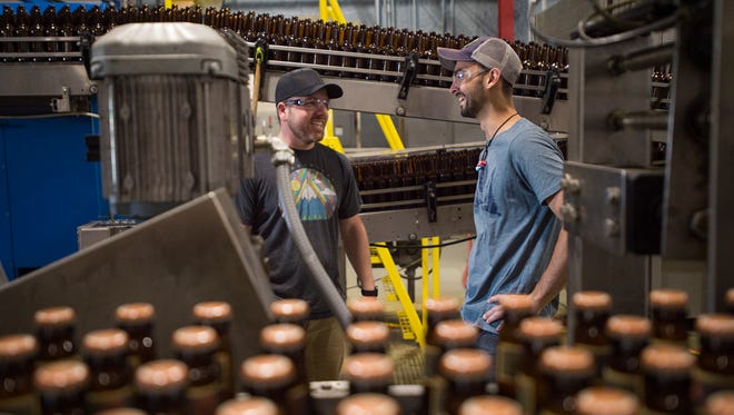 Dan Buzard and Evan Ide perform maintenance on the bottling line at Odell Brewing Co. Wednesday in Fort Collins. Odell's employee stock ownership plan makes employees like Buzard and Ide part-owners of the brewery.