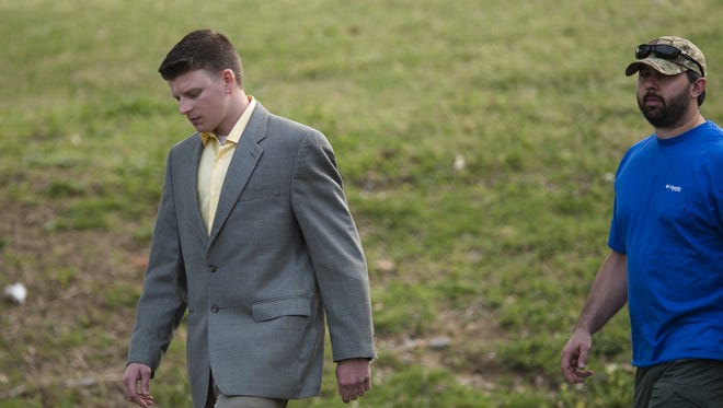 Aaron "A.C." Smith, left, walks away from the Montgomery County Circuit Court building in Montgomery, Ala., Wednesday, March 16, 2016, after a motion hearing in advance of his March 24 preliminary hearing. Smith, a Montgomery police officer, was charged with the Feb. 25 murder of 58-year-old Greg Gunn.
