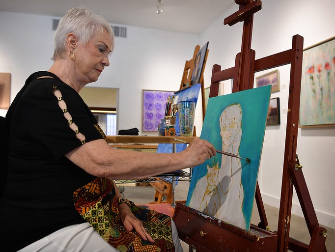 Artist Kitty Thompson works on a portrait at the new