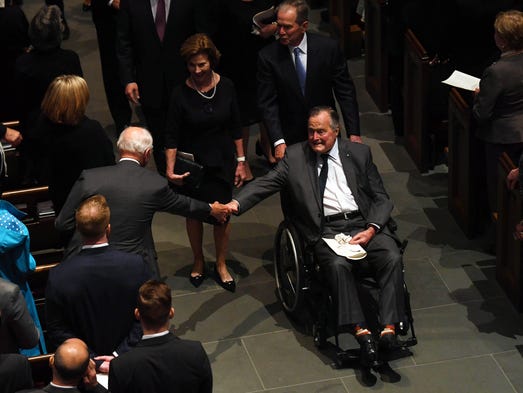 President George H.W. Bush is greeted as he exits the