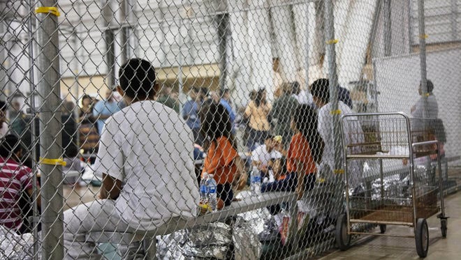 FILE - In this Sunday, June 17, 2018 photo provided by U.S. Customs and Border Protection, people who were taken into custody related to cases of illegal entry into the United States, sit in one of the cages at a facility in McAllen, Texas. On Wednesday, June 20, 2018, The Associated Press has found that stories circulating on the internet that President Barack Obama did not oversee the separation of 90,000 migrant children and their parents at the U.S. border are untrue. (U.S. Customs and Border Protection's Rio Grande Valley Sector via AP)