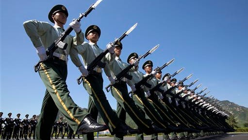 FILE - In this Aug. 22, 2015 file photo, Chinese troops practice marching ahead of a Sept. 3 military parade at a camp on the outskirts of Beijing. China is leaning on the animal kingdom - including a squad of nest-wrecking monkeys - to ensure its military parade commemorating the end of World War II goes smoothly. To minimize the chances of birds striking engines during the many airplane flyovers connected to the Beijing parade, state media reports say, the military has used falcons to chase away birds and a team of trained macaques to flush nests out of trees around the pilots’ training grounds. (AP Photo/Ng Han Guan, File)