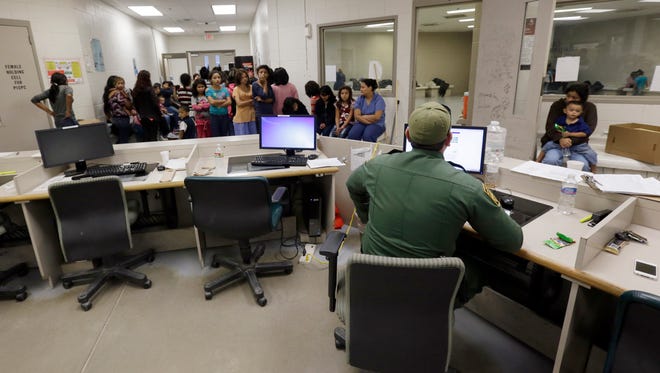 This June 18, 2014, file photo shows U.S. Customs and Border Protection agents work at a processing facility in Brownsville,Texas. A new "surge initiative" aims to identify and arrest the adult sponsors of unaccompanied minors who paid coyotes or other smuggling operations to bring young people across the U.S. border, Immigration and Customs Enforcement officials confirmed Thursday, June 29, 2017.